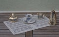 English teacup and saucer, cream jug, sugar bowl and sugar spoon, with floral decor, and metronome for music on a sheet of music