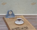 English teacup and saucer in front of a pale blue Wedgwood watch, Jasperware, on an old German daily newspaper Der Patriot