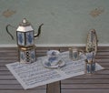 English teacup and saucer, silver-plated teapot spoon vase, teaspoon, cream jug and metronome for music on a sheet of music