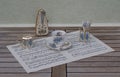English teacup and saucer, spoon vase, teaspoon and cream jug and metronome for music on a sheet of music