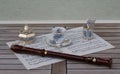 English teacup and saucer, spoon vase and teaspoon, sugar bowl and sugar spoon, and a block flute on a sheet of music