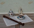 English teacup with saucer, sugar bowl, fine bone china porcelain, metronome for music and a block flute on a sheet of music