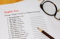 English test sheet on wooden desk Royalty Free Stock Photo