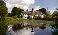 An English Thatched House by a Duckpond. Royalty Free Stock Photo