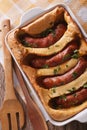 English toad in the hole into a baking dish close up. Vertical t Royalty Free Stock Photo