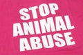 The English words stop animal abuse printed on a red pinkish maroon fabric material Royalty Free Stock Photo