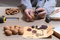 An engraving specialist performs the work of opening and processing walnuts in accordance with an old drawing lying in the Royalty Free Stock Photo
