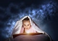 Engrossed little girl reading book in bed Royalty Free Stock Photo