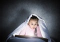 Engrossed little girl reading book in bed Royalty Free Stock Photo