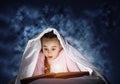 Engrossed little girl reading book in bed Royalty Free Stock Photo