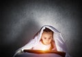 Engrossed little girl reading book in bed Royalty Free Stock Photo