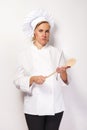 Engry chef woman with spoon over white background look at camera