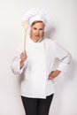 Engry chef woman with spoon over white background look at camera