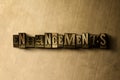 ENHANCEMENTS - close-up of grungy vintage typeset word on metal backdrop Royalty Free Stock Photo
