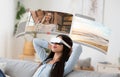 Young asian woman dives into virtual reality for video chats from home, relaxing on sofa with digital screens