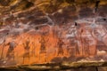 enigmatic cave paintings on a dark sandstone wall