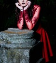 Enigmatic Gothic Beauty - Slender Woman in Red Dress Amidst Dark Forest Royalty Free Stock Photo