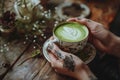 Enigmatic Latte Ritual: Tattooed Hands Reverently Hold a Cup of Antioxidant-Packed Matcha, Creating a Spellbinding Royalty Free Stock Photo