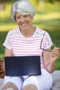 enior woman with tablet pc computer at summer park Royalty Free Stock Photo