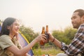 Enjoy asian young woman, girl and man cheering with beer bottle, sitting on chair . Adventure couple, people camping in forest. Royalty Free Stock Photo
