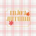 `Enjoy Autumn` lettering with autumn/fall leaves on cozy plaid background.