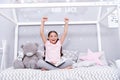 Enjoy concept. Happy girl enjoy staying in bed. Little child with raised hands enjoy reading book. Enjoy life