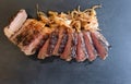 Sirloin steak sliced with caramelised onion on black slate