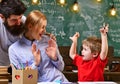 Enjoy drawing together. Child with mother and father sit at desk. Little kid study painting. Family is learning in class Royalty Free Stock Photo