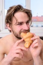 Enjoy every bite. Man eats croissant he likes bakery products. Guy bites sweet dessert. Man bearded handsome guy eating