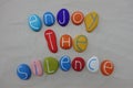 Enjoy the Silence text with colored stones over white sand