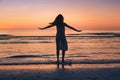enjoy life in summer, silhouette of happy beautiful woman dancing on sunset beach Royalty Free Stock Photo