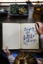 Enjoy little things phrase written on notepad