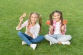 Enjoy these lollipops with taste sensation. Happy children hold lollipops green grass. Eating large swirl lollipops on