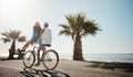 They enjoy long cycles along the beach. a young couple riding a bicycle together on the promenade. Royalty Free Stock Photo