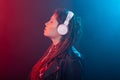 Enjoy, meloman and people concept - young woman with dreadlocks listening to the music, portrait over the dark Royalty Free Stock Photo