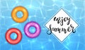 Enjoy Summer and Colored Swim Rings on Water Background