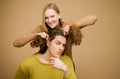 Enjoy twogether. A blonde girlfriend making funny hairstyle to her boyfriend with curly hair. Young couple doing a joke Royalty Free Stock Photo