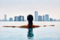 Bavk view of young woman swimming in swimming pool on roof top Royalty Free Stock Photo