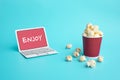 Enjoy with vdo entertainment or movie concepts with text on paper art laptop and pop corn on color Royalty Free Stock Photo