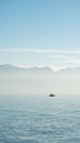 Lake Geneva, Lac Leman, Lausanne in winter, With lonely fishing boat and snow mountains in the background Royalty Free Stock Photo