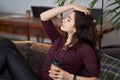 Enjoy weekend. Asian girl relaxing, drinking coffee and sitting on a couch Royalty Free Stock Photo