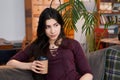 Enjoy weekend. Asian girl relaxing, drinking coffee and sitting on a couch Royalty Free Stock Photo