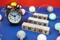 Enjoy Your Day alphabet letter and alarm clock decorate with LED cotton ball on blue and red background