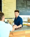 Enjoy your drink. Barista handsome stylish hipster communicate with client visitor. Barista at bar of modern cafe ready