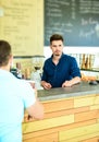 Enjoy your drink. Barista handsome stylish hipster communicate with client visitor. Served coffee to go. Man ask for Royalty Free Stock Photo