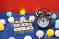 Enjoy Your Life alphabet letter and alarm clock decorate with LED cotton ball on blue and red background