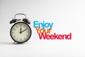 ENJOY YOUR WEEKEND inscription written and alarm clock on white background Royalty Free Stock Photo