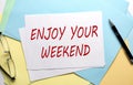 ENJOY YOUR WEEKEND text on paper on the colorful paper background