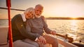 Enjoying amazing sunset. Happy senior couple, elderly man and woman holding hands, hugging and relaxing together while Royalty Free Stock Photo