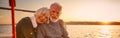 Enjoying amazing sunset. Happy senior couple, elderly man and woman holding hands, hugging and relaxing together while Royalty Free Stock Photo